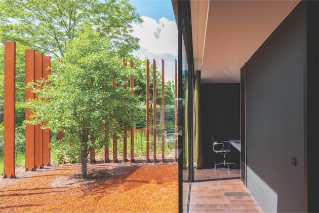 Vertikalūs „surūdijusio“ metalo stulpeliai - teritorijos riboženklis. Jais nužymėtas baseinas, prausimosi ir higienos zonos. 