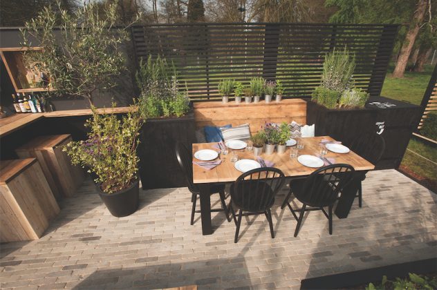 Prie masyvaus valgomojo stalo - vakarienė šešiems. Po atviru dangumi, augalų apsuptyje valgymo malonumas padvigubėja.