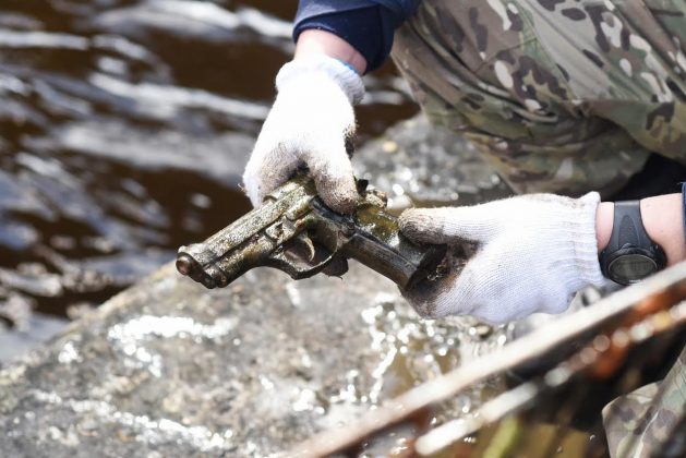 Nevėžio upę išvalyti pasišovę narai dugne rado ne tik stiklinių butelių, prekybos centro vežimėlį, kelio ženklų, bet ir rūdyti pradėjusį ginklą. (M. Blinstrubytės nuotr.)