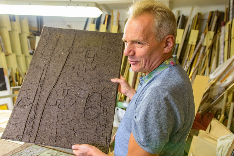 Prieš šešerius metus kūrėją savyje pažadinusi Laima Vološkevičienė dabar kuria paveikslus iš žemių. Juos rėmina autorės vyras. M. GARUCKO nuotr.