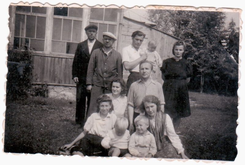 Panevėžio konditerijos, vaisių ir daržovių kombinato darbuotojai V. Gasiūno vaisių medelyno ūkyje. Iš kairės stovi ūkio savininkas V. Gasiūnas, kombinato vairuotojas A. Juršas, su vaiku ant rankų būsimasis direktorius M. Švecas, šalia jo žmona Vera, žemiau priklaupęs kombinato direktorius B. Žmoginas, apačioje sėdi direktoriaus sesuo K. Vitkauskienė, prie jos sūnus Viktoras Ramutis, šalia direktoriaus sūnus ir dvi kontoros darbuotojos.1946 metų liepa. Viktoro Ramučio VITKAUSKO kolekcijos nuotr.