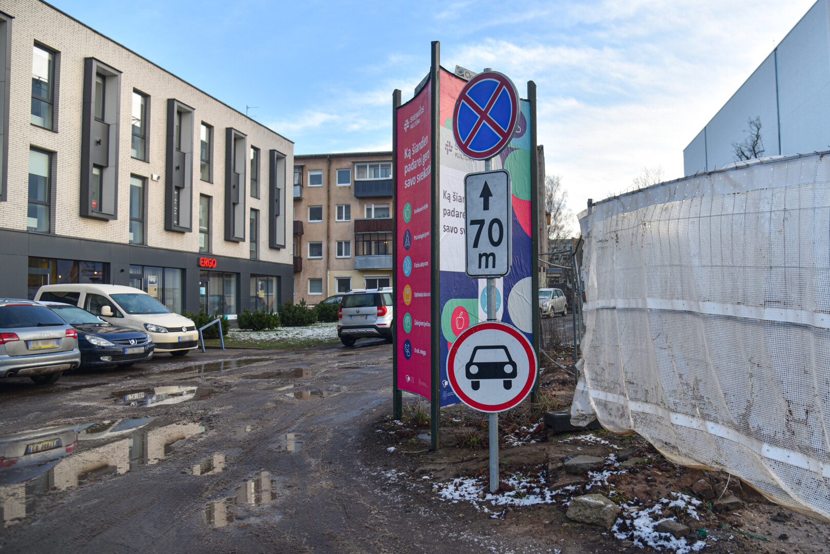 Topolių alėja savotiškais spąstais virto ir dėl duobių, ir dėl automobilių, statomų ten, kur kelių eismo ženklas draudžia jiems stovėti. P. ŽIDONIO nuotr.