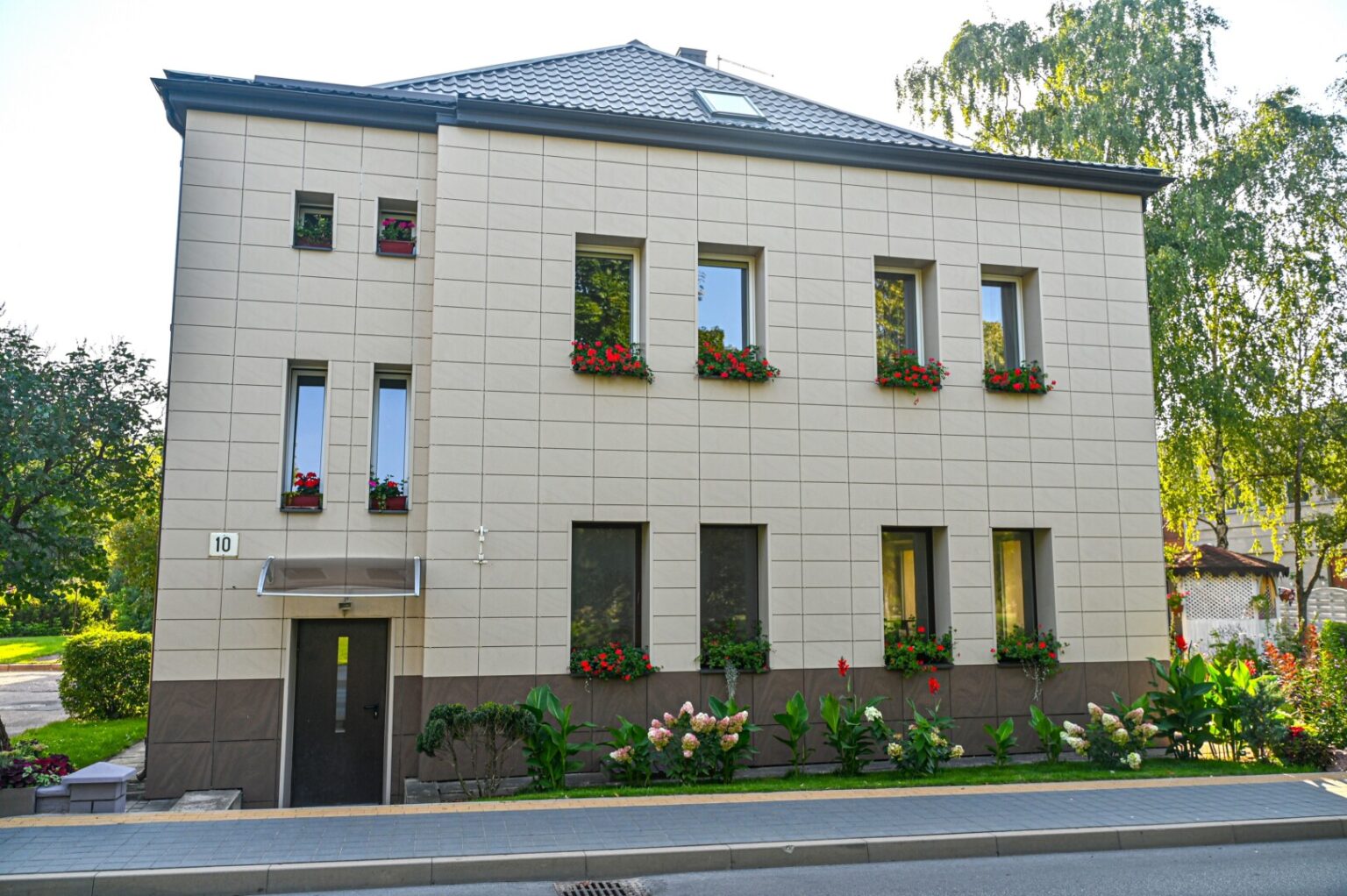 Keliaujantieji A. Jakšto gatve nejučia sulėtina žingsnį ties 10-uoju numeriu pažymėtu daugiabučiu. Akį patraukia kaskados nuo palangių svyrančių žiedų, namą supantys ištaigūs gėlynai.