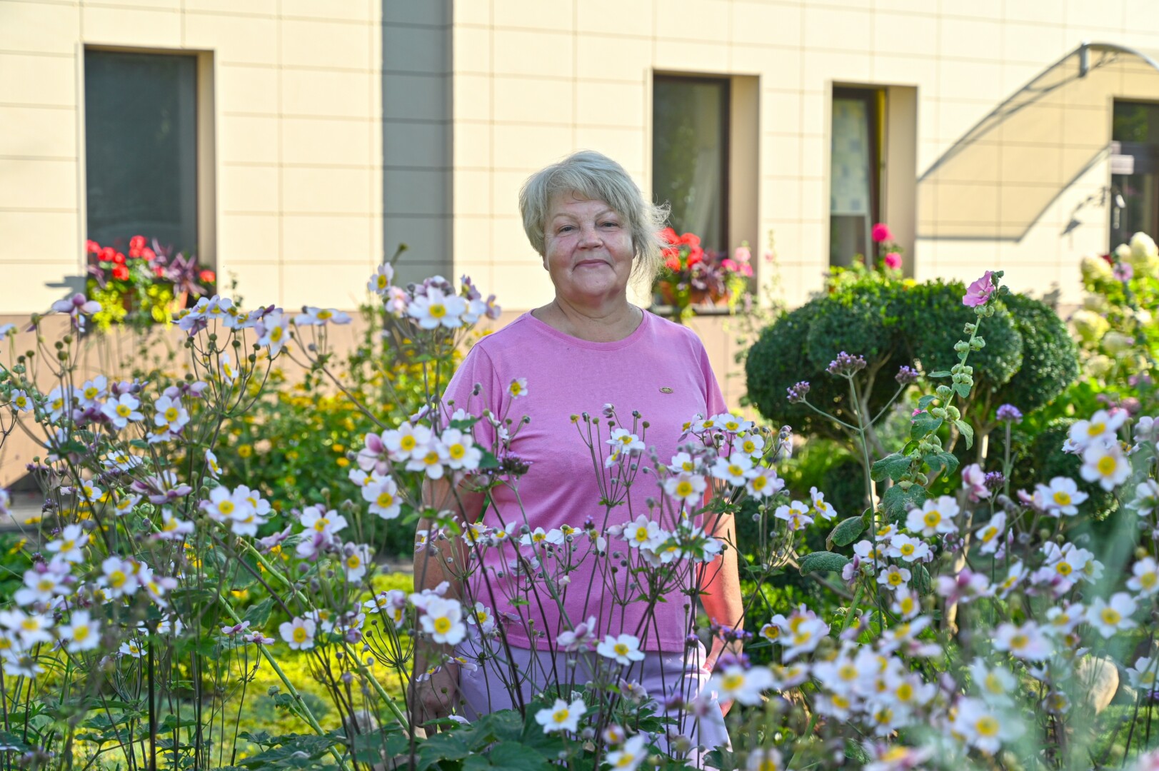 Įspūdingos aplinkos daugiabučio bendrijos pirmininkė Janinai Jasiūnienė džiaugiasi, kad idėjai puoštis pritaria visi kaimynai. Gyventojai išgražino net ir praeivių akims nematomus kampelius. G. KARTANO nuotr.