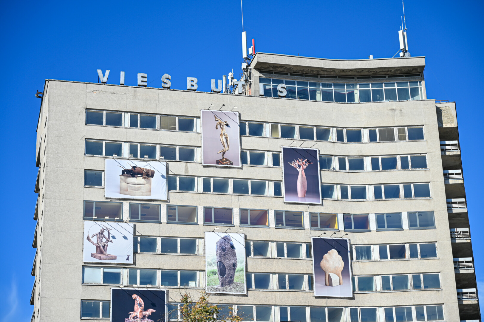 Varganai atrodančio viešbučio fasadą pavertęs meno galerija po atviru dangumi panevėžietis Albinas Vološkevičius teigia, jog daugiau nei prieš metus pakabinta ekspozicija nebeatlaikė laiko išbandymų. P. ŽIDONIO nuotr.