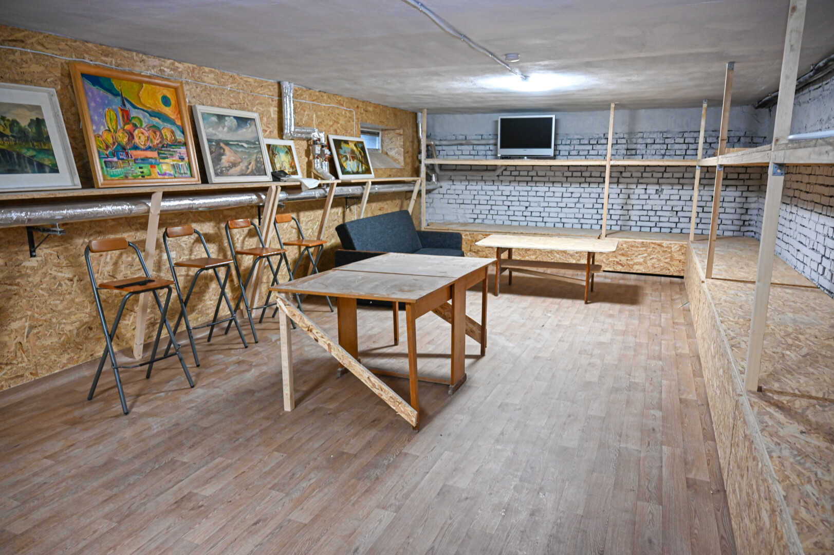 Iš bendrų rūsio patalpų išnešę nereikalingus daiktus ir išvalę per daugybę metų susikaupusias dulkes, buvo dezinfekuotos ir naujai perdažytos sienos, sudėtos laminato grindys, o palei sienas įrengti dviejų aukštų gultai. Slėptuvėje atsirado ir televizorius, vargonėliai, įvairių stalo žaidimų. P. ŽIDONIO nuotr.