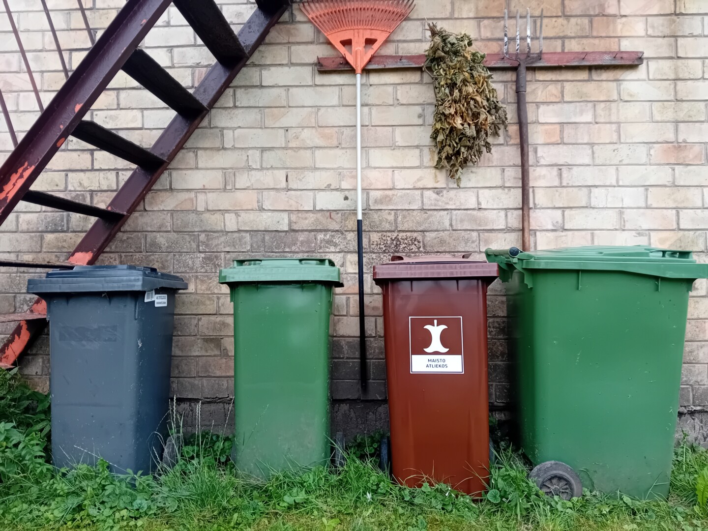 Konteinerių, skirtų maisto ir virtuvės atliekoms, atsiimti sukviesti Rožyno gyventojai po pirmos dalybų dienos džiaugiasi išnešę sveiką kailį.