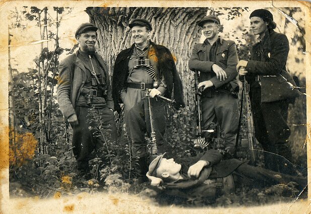 Vyčio apygardos Briedžio rinktinės Aro būrio partizanai prie storo ąžuolo kamieno. Ramygalos valsč. (dab. Panevėžio r.), apie 1948–1949 m. Kauno IX forto muziejaus rinkiniai (KDFM 35877).