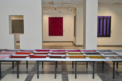 Panevėžio dailės galerijoje veikiančios parodos „Etnografinis opartas muziejų kolekcijose. Kazio Varnelio tapyba ir tradicinės lovatiesės“ organizatorius – Panevėžio kraštotyros muziejus.